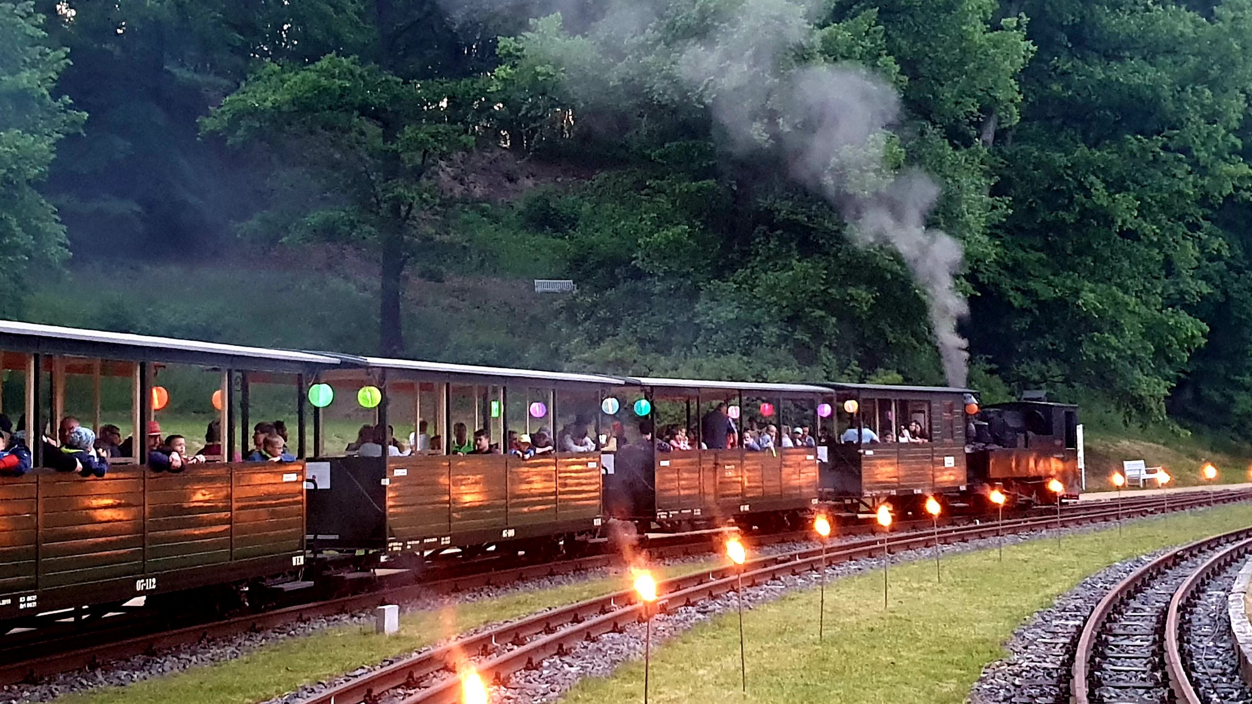 Beleuchteter Zug in der Abenddämmerung